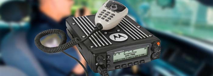 Um radio comunicador Motorola com fundo desfocado de policial usando radio.
